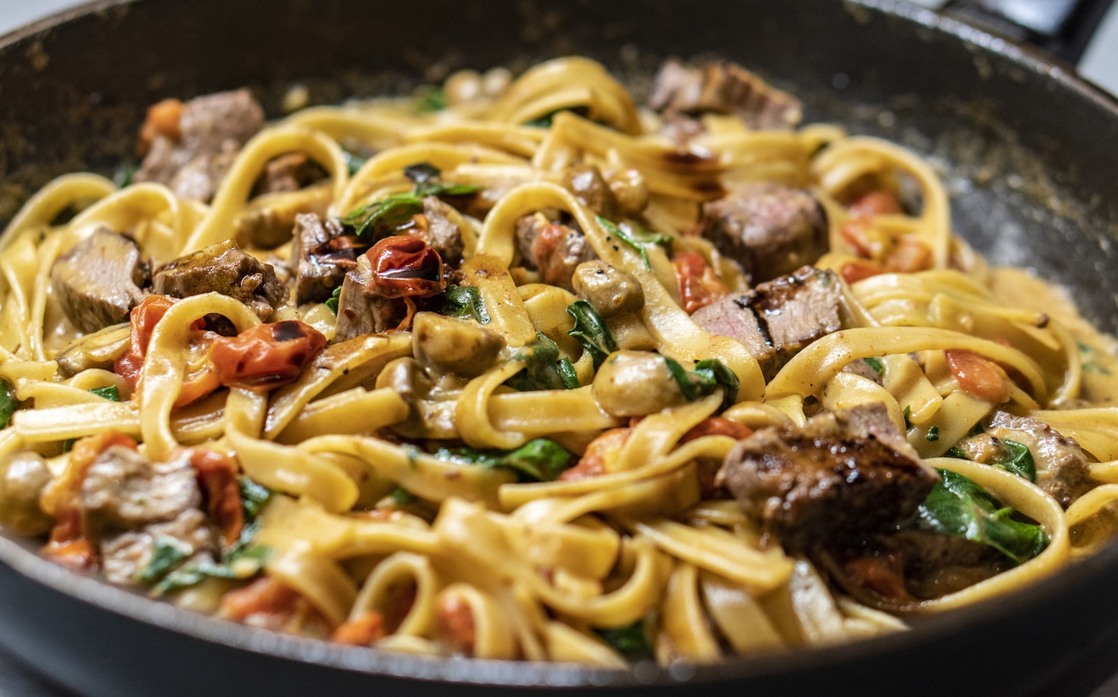 Mediterranean pasta with grilled meat and tomato